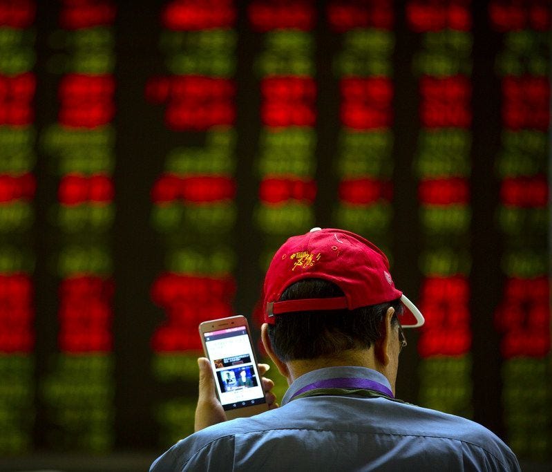 A Chinese investor listens to a news report on his smartphone as he monitors stock prices at a brokerage house in Beijing, on July 6, 2018.