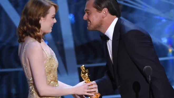 Leonardo DiCaprio, right, presents Emma Stone with the award for best actress in a leading role for "La La Land" at the Oscars on Sunday, Feb. 26, 2017, at the Dolby Theatre in Los Angeles. (Photo by Chris Pizzello/Invision/AP)