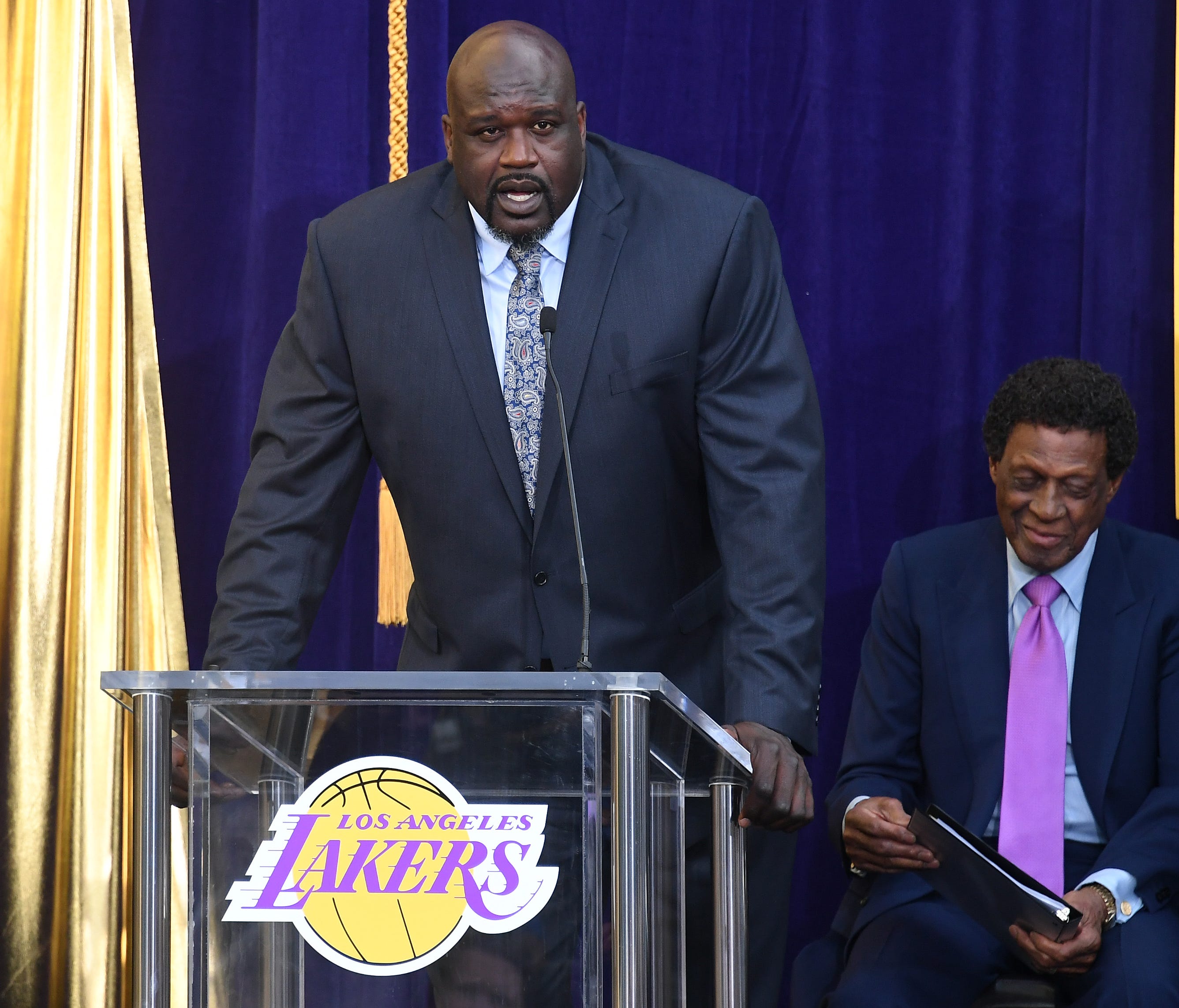 Former Los Angeles Lakers player Shaquille O'Neal (L) speaks during a statue unveiling for former player Elgin Baylor (R) prior to the game between the Los Angeles Lakers and the Minnesota Timberwolves at Staples Center.