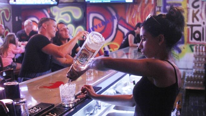 Ariatna Carmona, a bartender with the Beastie Bar in Cape Coral, mixes drinks for customers on Saturday night. The Beastie Bar is one of many new hang-outs in South Cape and more are on the horizon.