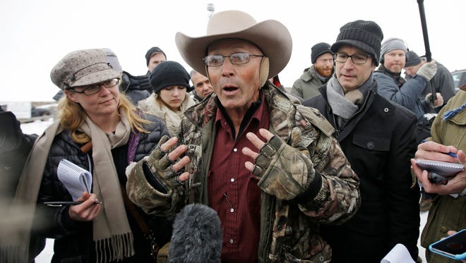 FILE - In this Jan. 5, 2016 file photo, Robert "LaVoy" Finicum, center, a rancher from Arizona, talks to reporters at the Malheur National Wildlife Refuge near Burns, Ore. An FBI agent has been indicted on accusations that he lied about firing at Finicum in 2016 when officers arrested leaders of an armed occupation of a federal wildlife refuge in rural Oregon. Sources familiar with the case say the agent will face allegations of making a false statement with intent to obstruct justice, The Oregonian/OregonLive reported Tuesday, June 27, 2017. (AP Photo/Rick Bowmer, File)
