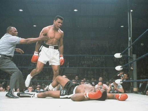 World heavyweight champion Muhammad Ali is held back