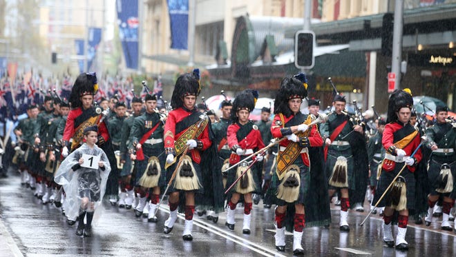FILE - In this April 25, 2014 file photo, a pipe band marches on George Street during the ANZAC Day parade, in Sydney, commemorating the anniversary of the first major military action fought by Australian and New Zealand Army Corps (ANZAC) during the First World War. Five Australian teenagers were arrested Saturday, April 18, 2015 on suspicion of plotting an Islamic State-inspired terrorist attack at an ANZAC Day ceremony that included targeting police officers, officials said. (AP Photo/Rick Rycroft, File)
