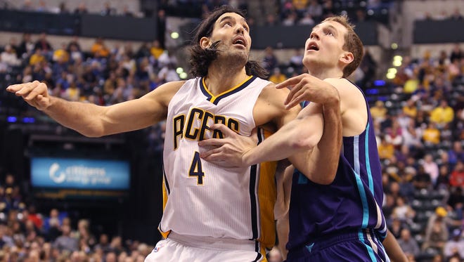 Indiana-native Cody Zeller of the Charlotte Hornets, right, and Indiana Pacer Luis Scola fight for position during second-half action at Bankers Life Fieldhouse in Indianapolis on Wednesday, Nov. 19, 2014. The Pacers won 88-86.