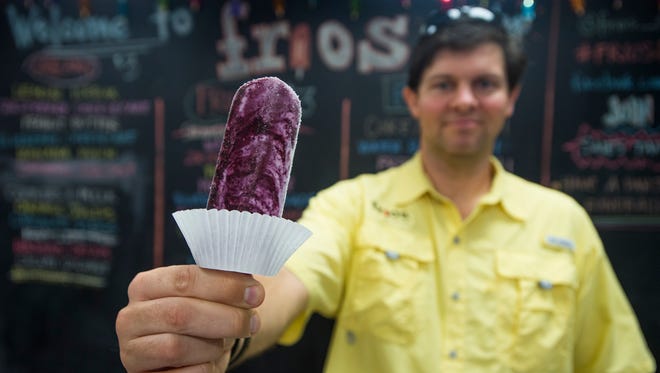 Troy Stubbs, owner of the Prattville, Wetumpka and soon to be opened Montgomery Frios Gourmet Pop Shops, serves a blueberry cheesecake popsicle at his store in Prattville, Ala. on Monday August 15, 2016.