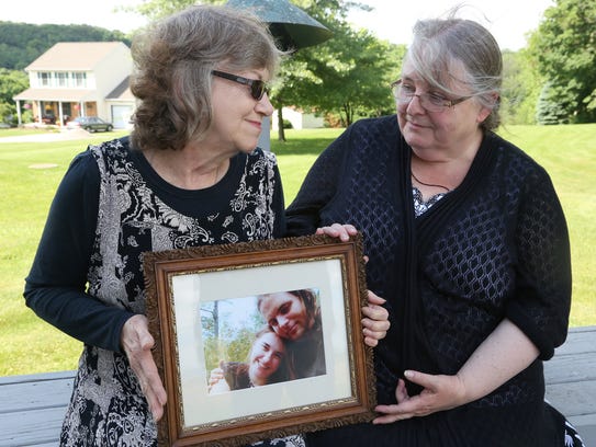 Lyn Coleman and Linda Boyle hold a picture of the children