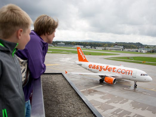 A family watches as an easyJet Airbus A320 passes by