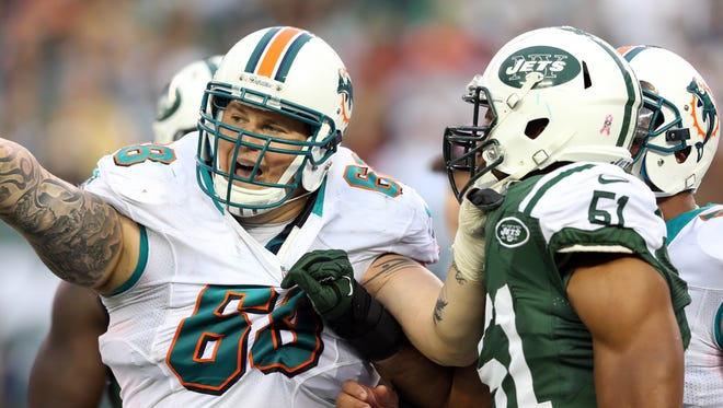 Miami Dolphins guard Richie Incognito (68) and New York Jets linebacker Aaron Maybin (51) scuffle during the third quarter at MetLife Stadium.