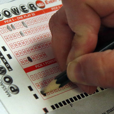  A customer fills out her Powerball lottery ticket