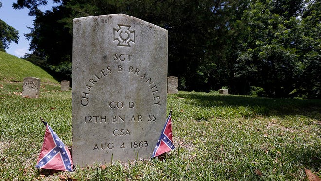 Two small faded Confederate battle flags flank the grave marker of Confederate soldier Sgt. Charles B. Brantley, who along with Private Reuben H. White are the only Confederate fighters buried in Vicksburg National Military Park in Vicksburg, Miss., Thursday, July 9, 2015. The Republican-controlled House scrapped a vote on permitting the Confederate flag at Park Service-run cemeteries on Thursday, a retreat under fire that only escalated a ferocious attack by Democrats complaining the banner celebrates a murderous, racist past.
