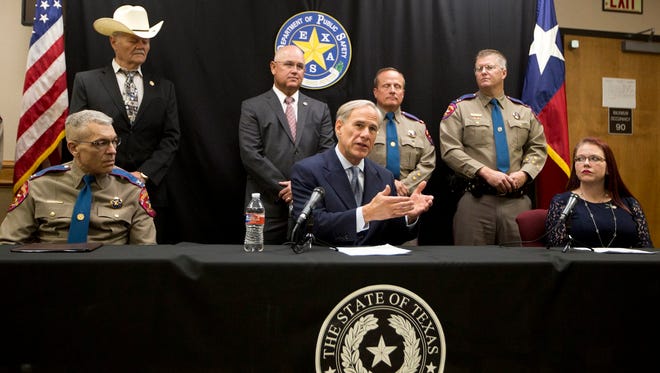Gov. Greg Abbott. joined by DPS Director Steve McCraw (seated, left) and Kasey Allen, widow of Damon Allen, speaks at a press conference in Waco on August 7, 2018. Abbott announced a proposal to reform the bail system in Texas. The proposal is in honor of State Trooper Damon Allen, who was killed while on duty in 2017.