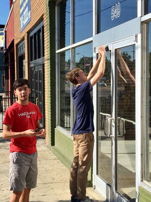 College students Christopher Galbreath (L) and Micah Dempsey show the space on the Highland Strip where they will open a combination pottery studio/coffee shop called Belltower Artisans.