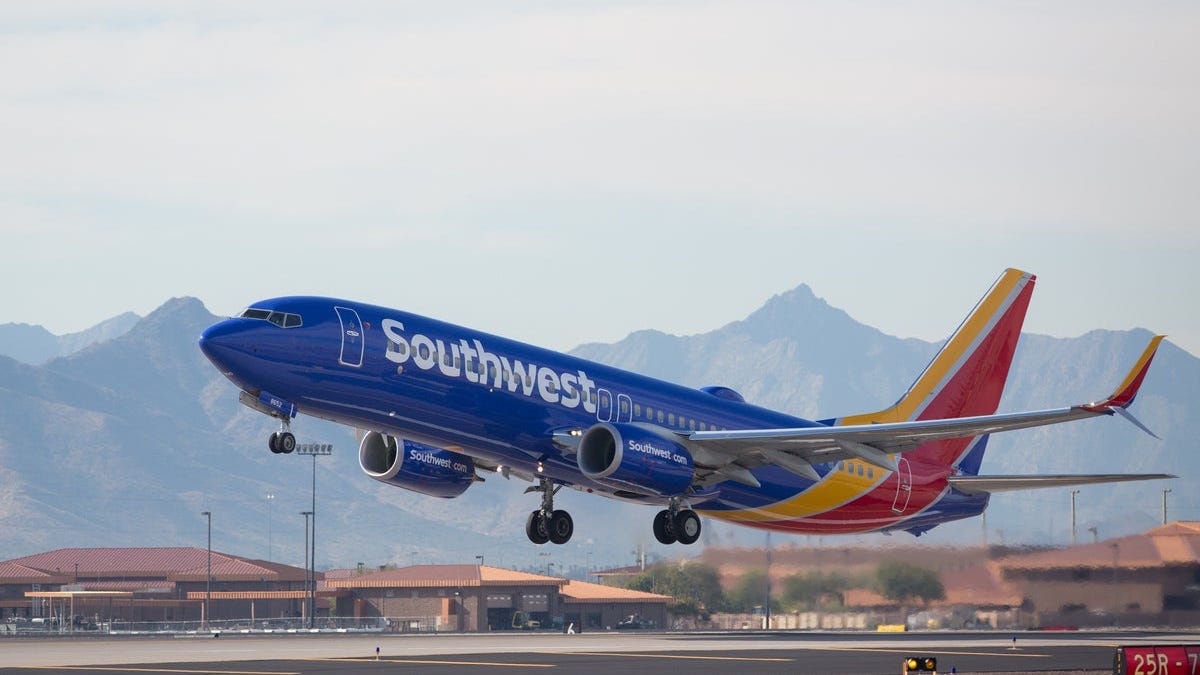 A Southwest Airlines plane preparing to land, with mountains in the background