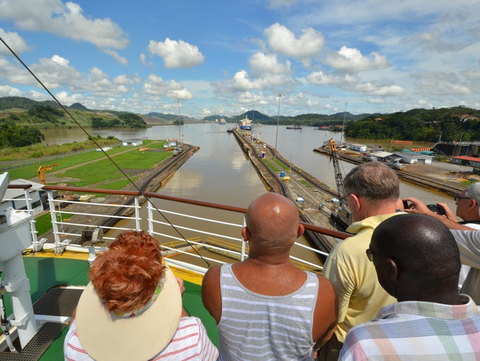 Passengers watch from the front of the Celebrity Millennium as it sails out of the Panama Canal's Miraflores Locks.