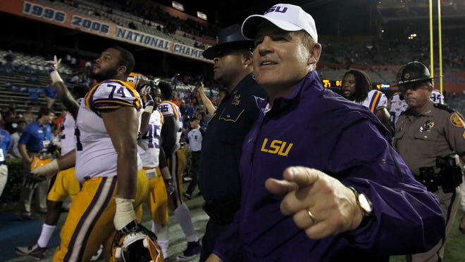 LSU Tigers head coach Les Miles celebrates as he walks off the field after they beat the Florida Gators at Ben Hill Griffin Stadium. LSU Tigers defeated the Florida Gators 30-27.