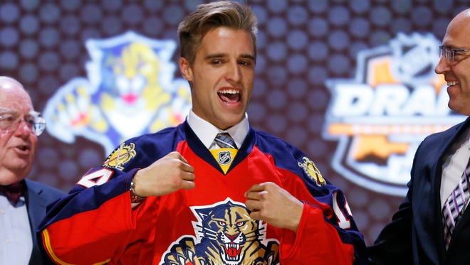 Aaron Ekblad pulls on a Florida Panthers sweater after they made him the first overall pick in the 2014 NHL Draft on Friday in Philadelphia.