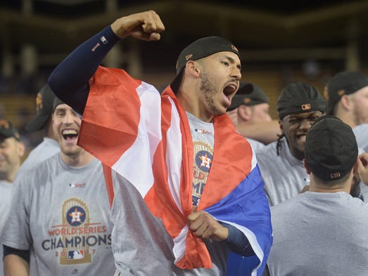 Carlos Correa celebrates with a Puerto Rican flag.