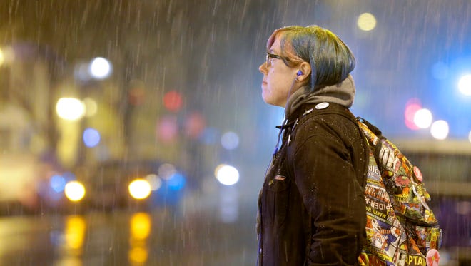 Bethany Eischen, of Milwaukee, waits for the light to change just as the snow starts to fall, as she walks home from work, on N. Old World 3rd. St. near W. Wells St. in Milwaukee on Sunday night. According to the National Weather Service in Sullivan, the Milwaukee area should expect six to 10 inches of snow between Sunday night and Tuesday afternoon.