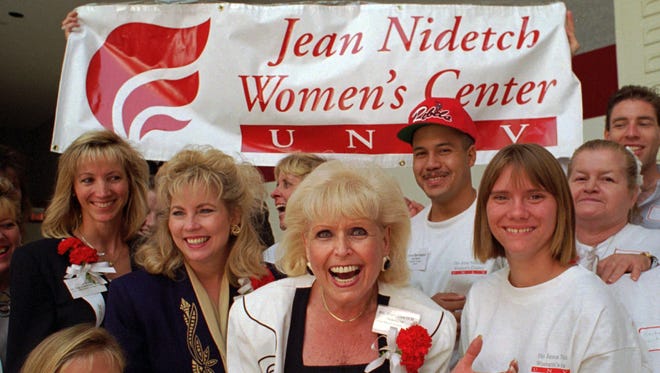 FILE - In this Sept. 9, 1995, file photo,  Jean Nidetch, center, founder of Weight Watchers International,  reacts with a group of workers from the Jean Nidetch Women's Center during a Jobs Fair on the campus of the University of Nevada at Las Vegas in Las Vegas. Nidetch, a New York housewife who tackled her own obesity problem, then shared her guiding principles with others in meetings that became known as Weight Watchers, the most widely known company of its kind, died Wednesday, April 29, 2015, at her home near Fort Lauderdale, Fla., her son David Nidetch said. She was 91. (AP Photo/Lennox McLendon, File)