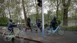 North Koreans push their bicycles in the rain on a