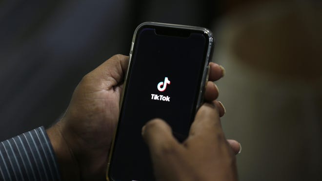FILE - In this July 21, 2020 file photo, a man opens social media app 'TikTok' on his cell phone, in Islamabad, Pakistan. U.S. Commerce announced Friday plans to block downloads of the app.