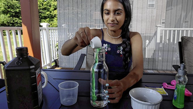 Olentangy Orange High School junior Nikitha Bhimireddy, 15, has created the Rising Youth, a website and YouTube channel to help children develop a passion for science. She also runs ScienceZoomz, in which she and her friends conduct experiments for children over weekly Zoom calls. Bhimireddy is pictured preparing an experiment called "elephant toothpaste," using hydrogen peroxide and other ingredients to create a foamy volcano.