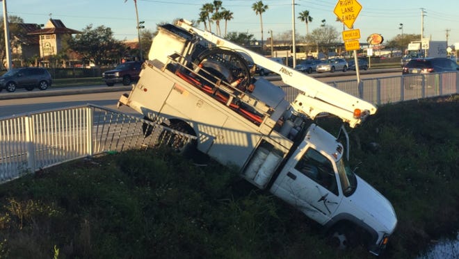 A truck was left hanging over the edge of a drainage canal Tuesday after a crash on Palm Bay Road.