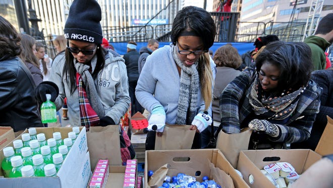 Members of Girl Scout Troop 48716 (from left) Amani Brooks, Deer Park High School, Ciara McCoy, Deer Park High School and Tori Russell, Walnut Hills High School, participate in the 7th annual Power Pack-a-Thon on Fountain Square, hosted by the Freestore Foodbank.