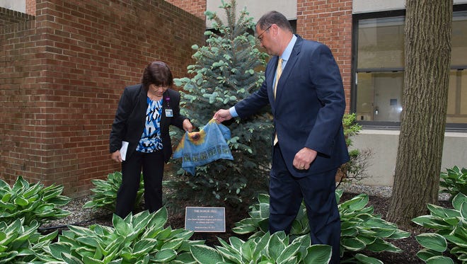 Marley Nicolas, MSN, RN, Administrative Director and Organ Donation Liaison, and Michael Mimoso, MHSA, FACHE, President & CEO, reveal the plaque in front of the Donor Tree at Community Medical Center.