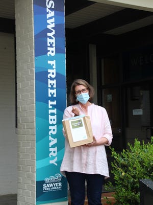 Assistant Library Director Beth Pocock shows how Sawyer Free Library is getting ready for curbside pickup.