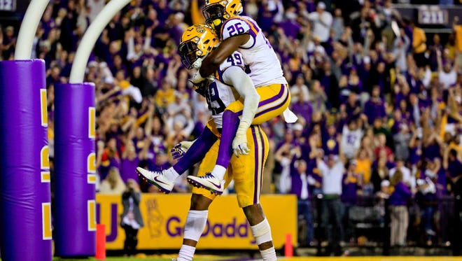 Oct 22, 2016; Baton Rouge, LA, USA; LSU Tigers defensive end Arden Key (49) and safety John Battle (26) celebrate after a defensive stop against the Mississippi Rebels during the second half of a game at Tiger Stadium. LSU defeated Mississippi 38-21. Mandatory Credit: Derick E. Hingle-USA TODAY Sports