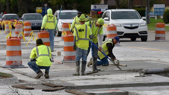 Construction crews lay concrete in the eastbound lanes of Seven Mile Road, west of Farmington Road.