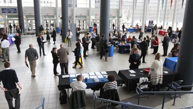 Job seekers circulate to different companies booths during a job fair at the War Memorial at the Blue Cross Arena.