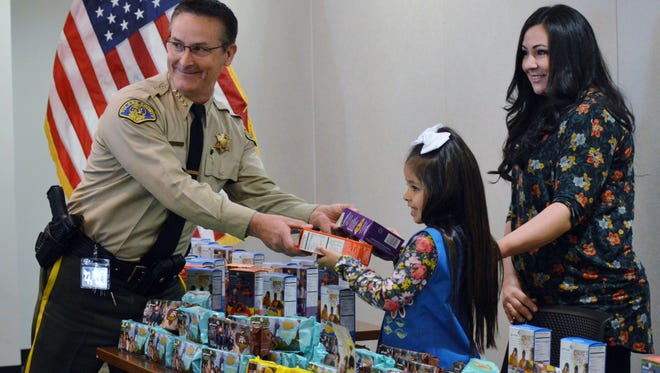 Girl Scout Daisy Savanah Padilla gives Sheriff Mike Boudreaux his favorite  Girl Scout cookies.