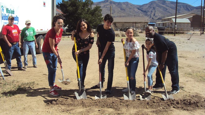 White Sands Habitat for Humanity Executive Director Kuia Taiaroa, Erica Desrosiers and her children and Pastor Charles Gardin break ground on Desrosiers' home.