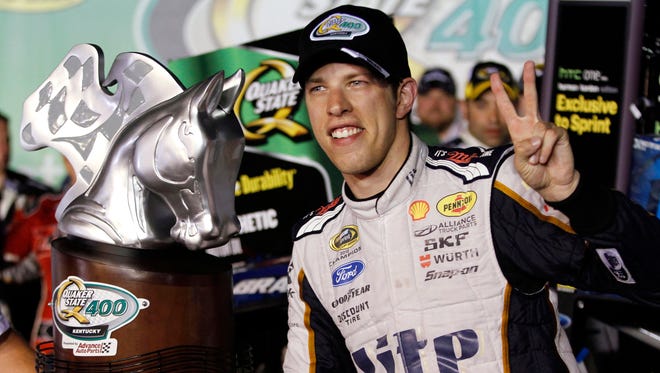 Brad Keselowski poses with the trophy after winning the NASCAR Sprint Cup series auto race Saturday, June 28, 2014, at Kentucky Speedway in Sparta, Ky. (AP Photo/James Crisp)