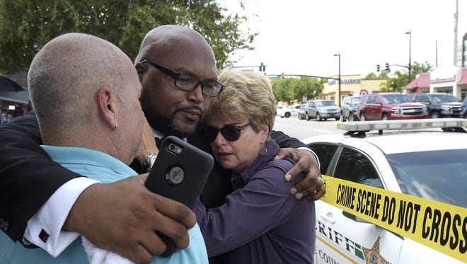 Terry DeCarlo, executive director of the LGBT Center of Central Florida, left; Kelvin Cobaris, pastor of The Impact Church, center; and Orlando City Commissioner Patty Sheehan console each other Sunday.