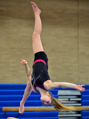 Sartell ninth-grader Abby Weber goes upside down during a move on the balance beam in practice Wednesday, Feb. 10, at Sartell High School.