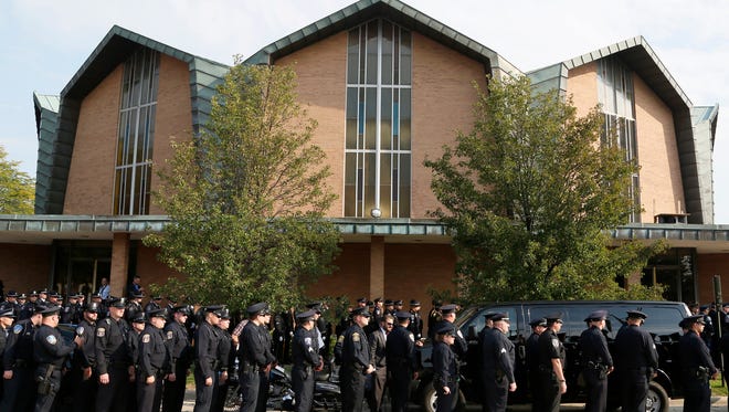 Police officers from departments around the Michigan line up to head inside St. Joan of Arc Catholic Church in St. Clair Shores on Friday, Sept. 23, 2016, for the funeral of Detroit Police Sgt. Kenneth (Shark) Steil, who died days after being shot while on duty.