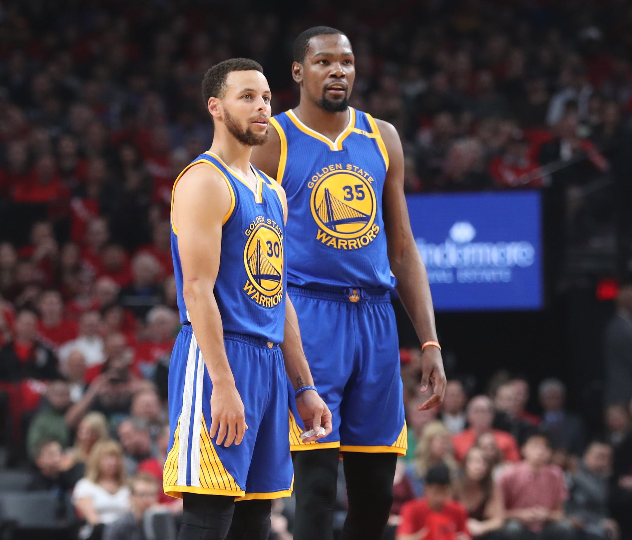 Stephen Curry and Kevin Durant look on from the court in the first half of Game 4 of the first round of the 2017 NBA Playoffs.