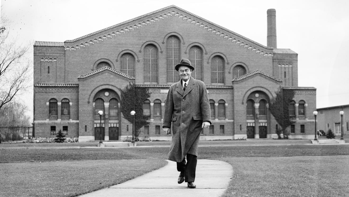 As athletic director at Michigan from 1921-41, Yost conceived and oversaw the building of today's modern athletic campus that included Michigan Stadium and Yost Field House, seen behind him in 1938.  It's now Yost Ice Arena.  