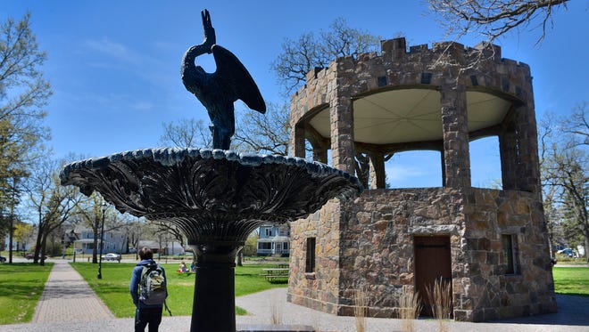 A student walks past the fountain and bandshell on his way through Barden Park during the noon hour Wednesday. The park is St. Cloud's oldest, founded in 1855.