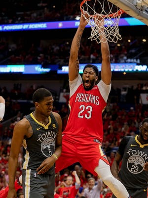New Orleans Pelicans forward Anthony Davis dunks over Golden State Warriors forwards Draymond Green and Kevon Looney during Game 3.