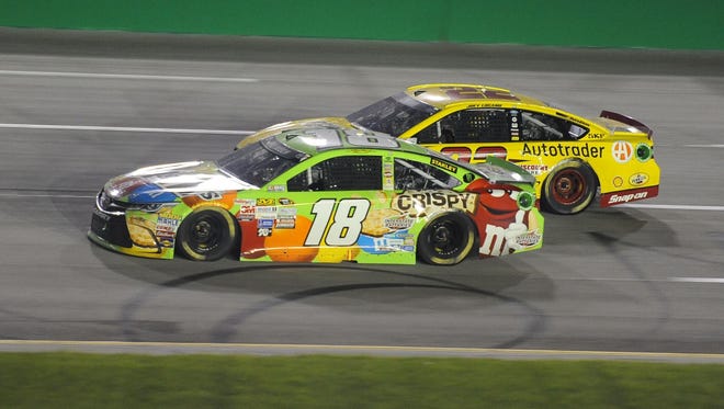 Kyle Busch passes Joey Logano (22) for the lead.