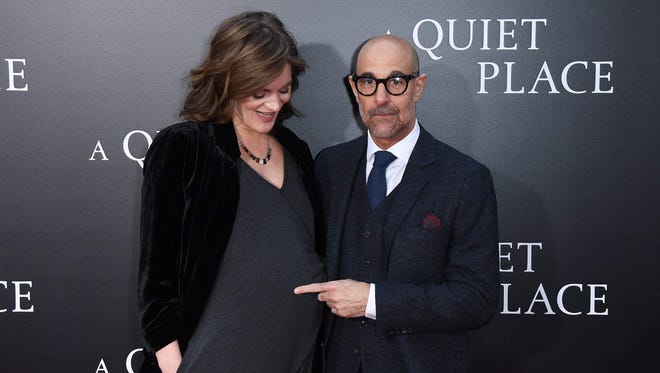 Actor Stanley Tucci, right, points to the baby bump of his wife, Felicity Blunt, at an early April premiere for 'A Quiet Place.' She gave birth to a daughter later in the month.