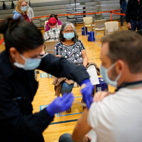 People get COVID-19 shots at a vaccination site in