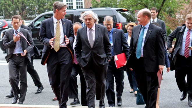 Left to right Charlie Riordan, deputy provost and research and scholarships at the University of Delaware, U.S. Secretary of Energy, Dr. Ernest Moniz  and Sen. Chris Coons, walk to the Patrick T. Harker Interdisciplinary Science and Engineering Laboratory for a tour of the facility on Friday morning.