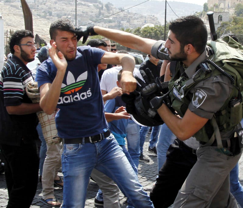 In this Oct. 2, 2015, file photo, an Israeli border policeman exchanges blows with a Palestinian man during a confrontation after Friday prayers outside the Old City in Jerusalem.