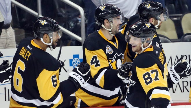 Penguins center Sidney Crosby (87) celebrates with teammates after scoring against the Devils.