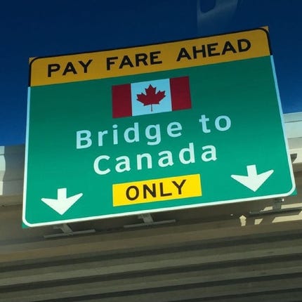 Sign posted on a freeway overpass pointing toward bridge to Canada.